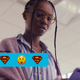 DC and the CW's live action Naomi wears glasses and is looking down at a text featuring Superman emoji.